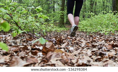 Pretty female running in the forest on side of a big City