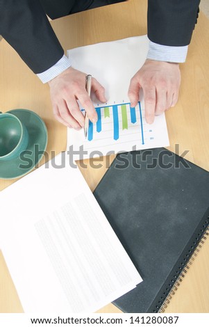 Graph chart and a Folder in Front of Man in Suite