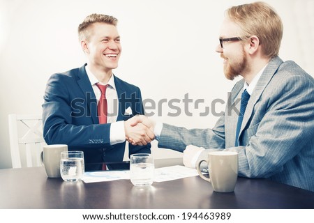 Two Sitting Men Handshaking