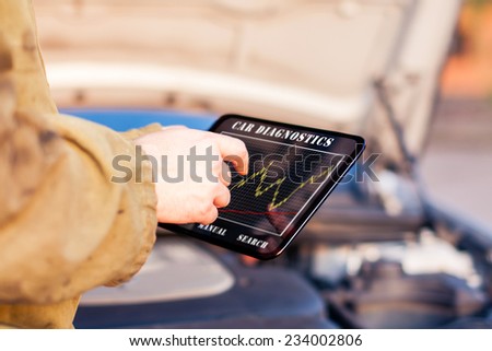Man in Front of a Car using Digital Tablet