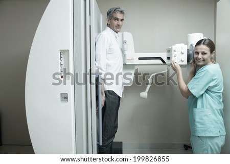 Female doctor with male patient at x-ray machine.