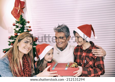 Happy family for Christmas. Parents and children happy together close to the tree.