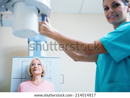 Senior woman undergoing ultrasound scan by young female doctor.