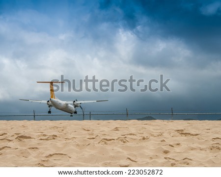 ST MAARTEN - APRIL 12, 2010: Low flying airplane lands near Maho Beach on the island of St Maarten in the Caribbean. it a favorite place to visit on the island.
