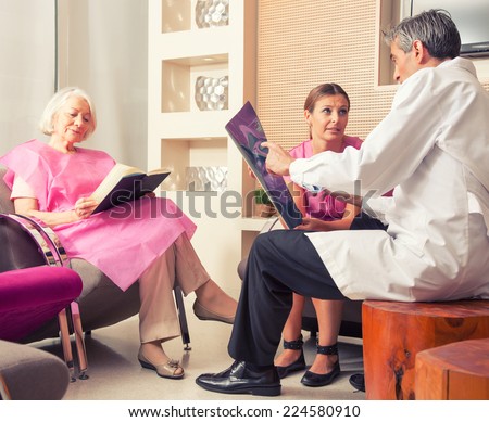 Woman in 40s asking questions to male doctor about medical exam results.
