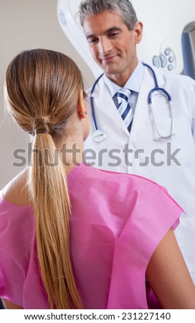Happy doctor reassuring female patient at the hospital. Health concept.