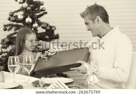 Child receiving gift from dad. Christmas concept.
