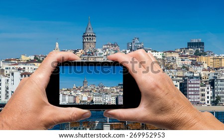 Man and woman sharing smartphone capturing Beyoglu skyline skyline