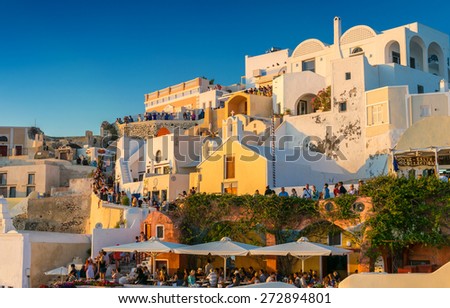 SANTORINI - JULY 11, 2014: People wait for sunset time in Oia town. Santorini is a major tourist destination in Greece.
