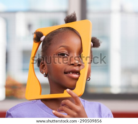 African schoolgirl joking with object in primary classroom.
