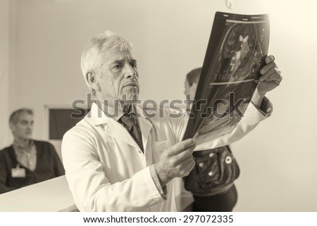 Expert doctor analyzing x-ray scan at hospital.