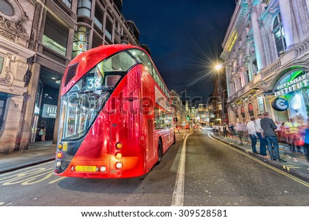 LONDON - JUNE 14, 2015: Red Double Decker Bus speeds up in city streets at night. These modern buses came to replace an old classic,the AEC Routemaster.