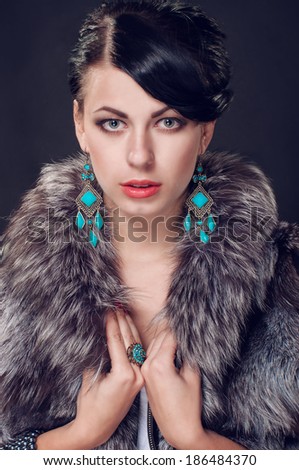 young woman in a fur coat in beautiful earrings