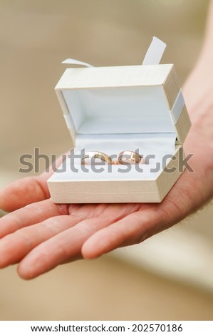 box with wedding rings in hands of the groom