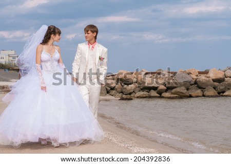 Young and beautiful bride and groom on the beach in summer