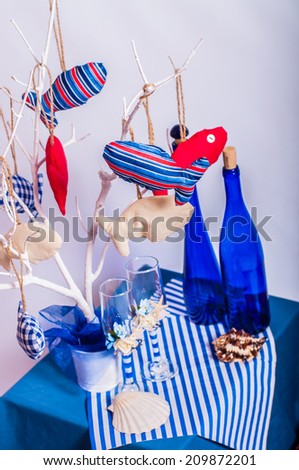 Decoration on the marine theme with seashells, fish, bottles and glasses