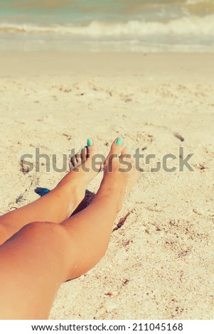 girl feet in the sand on the beach in summer