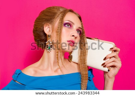 Beautiful girl in fashion dress with handbag clutch