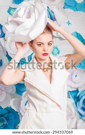 Pretty girl in fashionable dress with large paper flowers