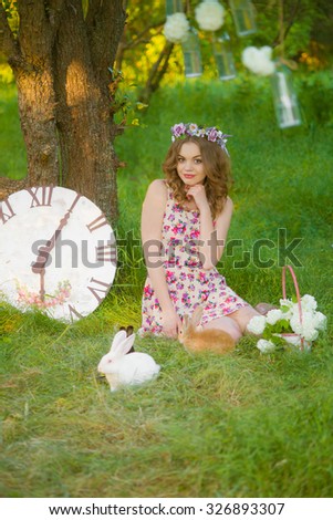 Beautiful girl with curly hair with rabbits spring park
