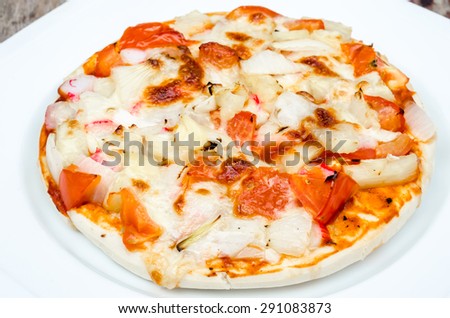 Pizza on white dish and wood table