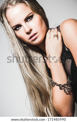 Close-up portrait of young woman with evening make-up, long blonde hair and strong look