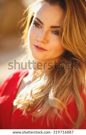 Gorgeous red head young woman in long red dress in a dessert. Sandy canyon. Fashion style