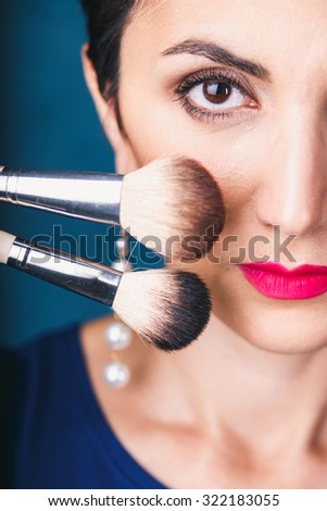Makeup. Make-up Face. Big Make up brush. Makeup applying concept. Beautiful strong woman face closeup. Skin tone. Facial powder