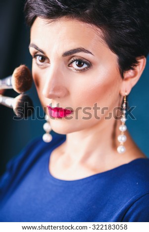 Makeup. Make-up Face. Big Make up brush. Makeup applying concept. Beautiful strong woman face closeup. Skin tone. Facial powder