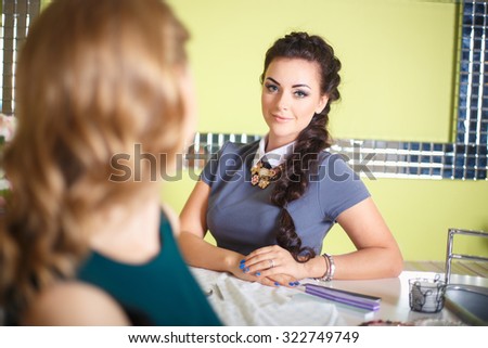 Close-up Of Beautician Hand Filing Nails Of Woman In Salon. Customer blonde woman and a beautician brunette