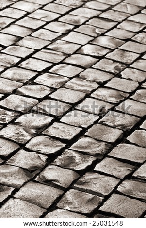 abstract medieval granite cobble road lit by evening sun