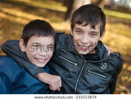 Portrait of two brothers. Brothers hugging each other in autumn park