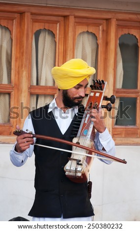AMRITSAR, INDIA, DEC - 7, 2014: Indian musician playing sarangi at Golden Temple (Harmandir Sahib also Darbar Sahib). Golden Temple is the holiest Sikh gurdwara located in the city of Amritsar