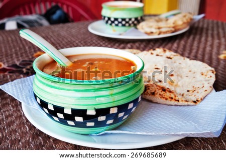 Indian tomato soup with chapati in Indian street restaurant