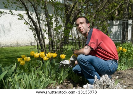 A happy gardener weeding the flower garden