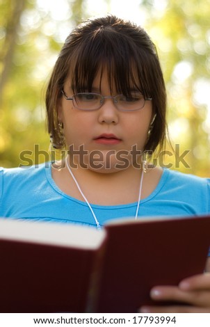 A nine year old girl studying from her text book for school