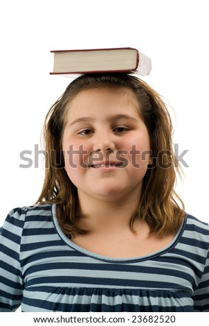 A young girl balancing a text book on her head, isolated against a white background