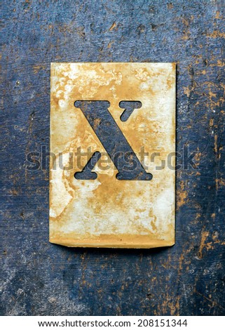 Metal typography over a weathered wood background showing the alphabet letter \
