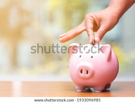 Concept hand putting money coin into piggy bank saving money for future plan and retirement fund, Business or finance saving show putting coin saving and investment money  retro vintage color tone.