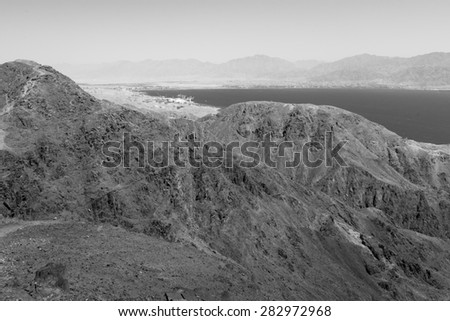Black and white Red sea mountains and Eilat Aqaba cities view, harbor seaport, Israel.