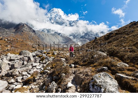 Young woman backpacker tourist standing looking Ama Dablam mountain snow peaks. Everest Base Camp trekking route trail, Nepal traveling tourism.