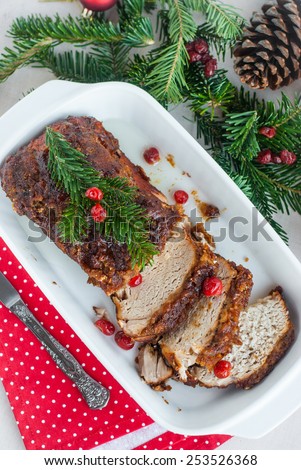 Roasted pork loin with cherries, spices and anise on celebratory table. Vertical