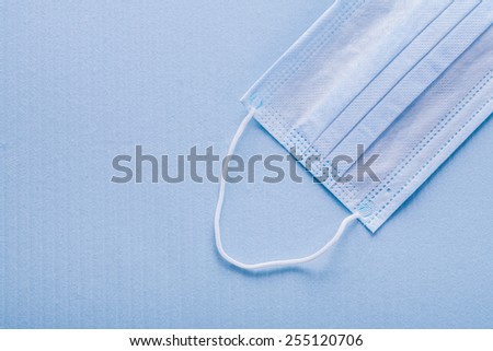 conceptual copyspace medical background disposable face mask on blue background