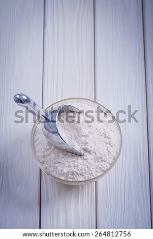 organnized copyspace bowl with flour and scoopon white painted wooden board food and drink still life