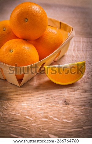 oranges in basket and slice of fruit on wooden board