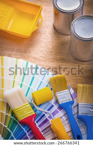 composition of painting tools paint brush roller tray can color palette on wooden board