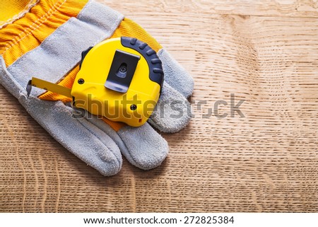 horizontal version tapeline and protective working glove on wooden board construction concept