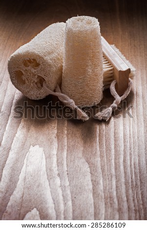 Vertical image of bath brush with loofahs on pine vintage wood board healthcare concept
