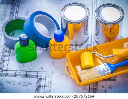 Blueprint with paint brush tray roller cans bottles and household tapes close up image construction concept.