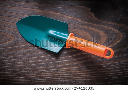 Hand gardening spade on vintage wood board agriculture concept.